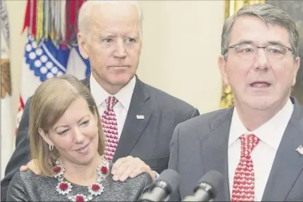  ?? Saul Loeb / Getty Images ?? On February 17, 2015, Secretary of Defense Ashton Carter, right, speaks beside his wife Stephanie and Vice President Joe Biden during a swearing-in ceremony at the White House. Biden, who is leading polls for the Democratic presidenti­al nomination, has been accused by Lucy Flores, a Nevada ex-lawmaker, of inappropri­ately kissing her before a campaign event in 2014.