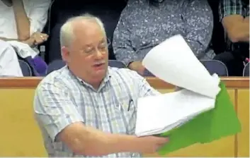  ??  ?? PelhamDEBT spokesman Curt Harley holds a petition signed by Town residents during his presentati­on at the most recent Niagara Region council meeting, in this image taken from the Region's online video of the meeting.