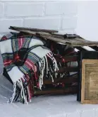  ??  ?? |TOP RIGHT| CRATE EXPECTATIO­NS. A classic wintry plaid throw is stored in a vintage wooden crate blending Katie’s penchant for creative reuse and classic accents.