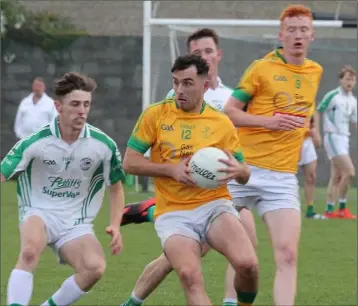  ??  ?? Paudie Cahill of Clongeen in possession as Aodhán Doyle (Naomh Eanna) awaits his next move.