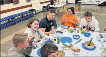  ??  ?? ■ Ben Brown pictured in the blue polo shirt, with Claudia Sayer to his right, at special cooking night with the Quantum Potatoes Explorer Scouts of the 2nd Loughborou­gh unit.