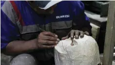  ?? ?? An inmate of the San Pedro prison works with wood to make handicraft­s to be sold at the Alasita fair in La Paz.