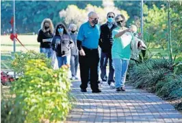  ??  ?? Pembroke Pines Mayor Frank Ortis takes a stroll
with Lisa Sigelbaum, founder and president of the Secret Garden at Century Village, after the nonprofit surprised the mayor with their new paved walkway
dedicated in his name.