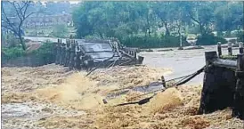  ?? CHANDAN PAUL / HT PHOTO ?? (Top) People navigate a water-logged road at Saraidhela Colony, Dhanbad; (above) A bridge washed away after heavy rain at Chinia road in Garhwa district.