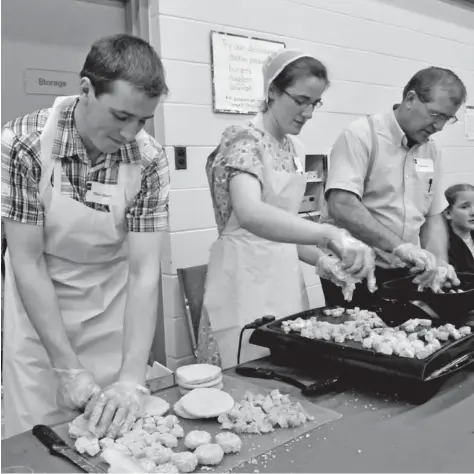  ?? [WILL SLOAN / THE OBSERVER] ?? Local farmers Paul Martin, Delphine Martin, and Glen Martin of Country Poultry Processing serve up their handiwork at Monday night’s annual Taste of Woolwich. The event, part of Woolwich Healthy Communitie­s Month, was designed to connect local food...