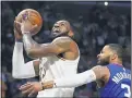  ?? MARK J. TERRILL — THE ASSOCIATED PRESS ?? LeBron James shoots as Clippers forward Marcus Morris Sr. defends during a March 8 game in Los Angeles.