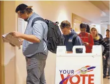  ?? ADOLPHE PIERRE-LOUIS/JOURNAL ?? University of New Mexico junior Kyle Craft consults a voter guide before casting his ballot Tuesday at the UNM Student Union Building.