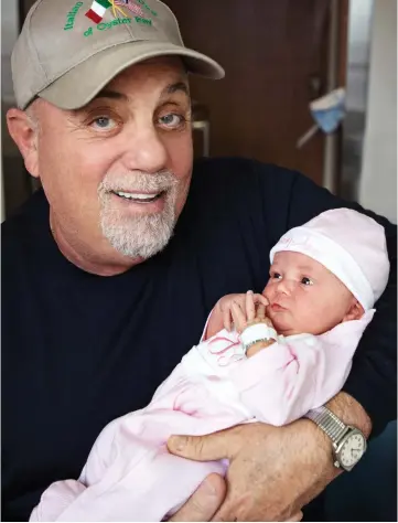  ??  ?? Practice makes perfect: Billy Joel cradles daughter Remy Anne, his third child