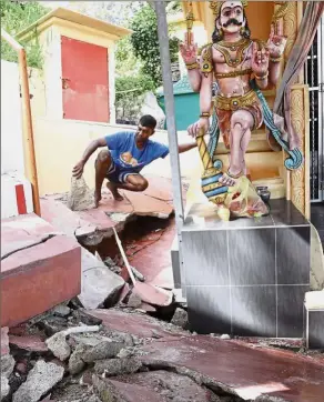  ??  ?? Badly affected: Temple caretaker R. Kesavan checking the damage at the Sri Aluvang Muneeswara­r Temple in Jalan Batu Ferringhi.