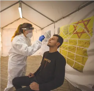  ?? (Olivier Fitoussi/Flash90) ?? A MAGEN DAVID ADOM medical worker tests people for coronaviru­s at a mobile site in Jerusalem last week.