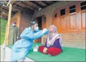  ?? WASEEM ANDRABI/HT ?? A health worker collecting a woman’s nasal swab outside her home in Budgam on Thursday.