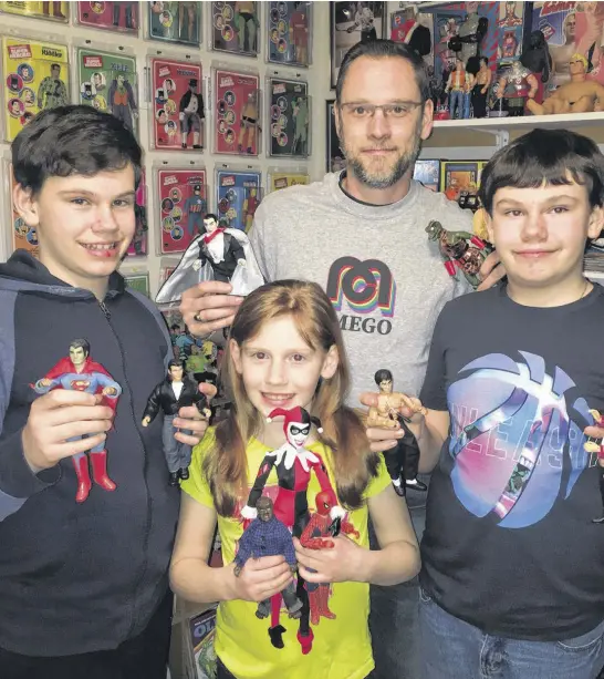  ??  ?? Art and graphic design is a hobby for Halifax resident Jason Young, who dabbles in it during his downtime from his regular job and raising his three kids — Jacob, left, Emily, and Nicholas, pictured with their dad in front of his collection of Mego Toys.