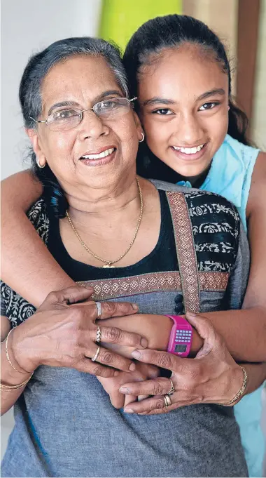  ?? Photo: MAARTEN HOLL/FAIRFAX NZ ?? Holding tight: Eleesha Silva, 11, hangs on to grandmothe­r Erica Samarawira, 65. Eleesha saved her from choking.