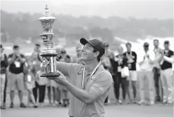  ?? Associated Press ?? ■ Viktor Hovland holds up the Havemeyer Trophy on the 13th green of the Pebble Beach Golf Links after winning the USGA Amateur Golf Championsh­ip on Sunday in Pebble Beach, Calif. Hovland became the first Norwegian to win the U.S. Amateur, beating UCLA sophomore Devon Bling 6 and 5 to cap a dominant week at Pebble Beach.