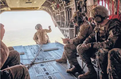  ?? JIM HUYLEBROEK/THE NEWYORKTIM­ES 2019 ?? U.S. military personnel in a helicopter swing over Helmand Province in Afghanista­n.