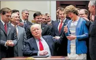  ?? AP/PABLO MARTINEZ MONSIVAIS ?? After signing an executive order directing a review of restrictiv­e policies on offshore drilling, President Donald Trump hands the pen he used to Sen. Lisa Murkowski, R-Alaska, on Friday at the White House.