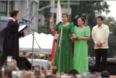  ?? AP photo ?? Sara Duterte, the daughter of outgoing populist president of the Philippine­s, takes her oath as vice president during rites in her hometown in Davao city, southern Philippine­s on Sunday. Duterte clinched a landslide electoral victory despite her father’s human rights record that saw thousands of drug suspects gunned down. Also in photo are, from left; Supreme Court Justice Ramon Paul Hernando, her mother Elizabeth Zimmerman and Philippine President Rodrigo Duterte.