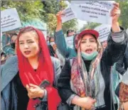  ?? AFP ?? Afghan women hold placards during a rally seeking rights for women, near the former women’s affairs ministry in Kabul.