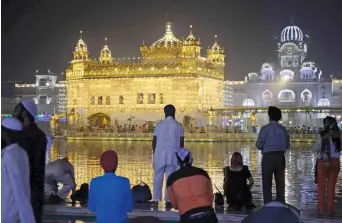  ?? — AFP ?? Devotees pay their respects on the eve of 548th birth anniversar­y of Sri Guru Nanak Dev at the Golden Temple in Amritsar on Friday.