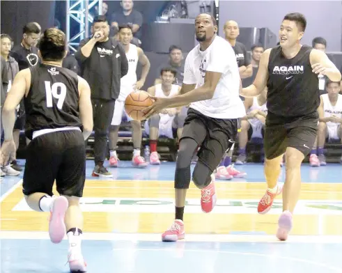  ??  ?? Kevin Durant of The Golden State Warriors plays hoops with Filipino cagers at the Smart Araneta Coliseum on Sunday.