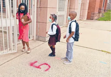  ?? BRAD HORRIGAN/HARTFORD COURANT ?? Principal Tayarisha Batchelor escorts fifth graders Javaina Spence and Tijaun Spence into Sarah J. Rawson Steam School. State education Commission­er Miguel Cardona said Thursday that classrooms are still the best place for learning.