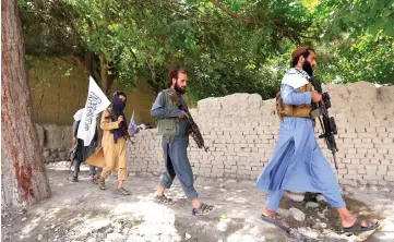  ??  ?? Taliban are seen walking as they celebrate ceasefire in Ghanikhel district of Nangarhar province, Afghanista­n in this file photo. — Reuters photo