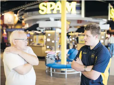  ?? — PHOTOS: THE WASHINGTON POST ?? ‘Spambassad­or’ Samuel Ehret, right, who has autism, answers a guest’s questions at the Spam Museum in Austin, Minn.