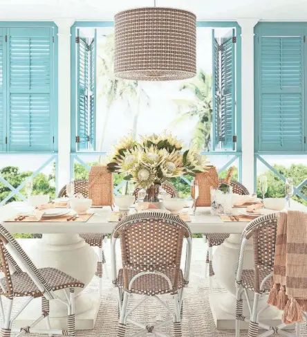  ?? PHOTOS PROVIDED BY SERENA AND LILY ?? Get from spring to summer with a refresh that includes a pretty table set with flowers. The blue shutters against a crisp white background are easy to do in any home looking for a happy color pick-me-up. Pictured is Serena and Lily’s Terrace table and Riviera dining chairs.