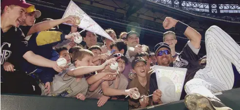  ?? John Leyba, The Denver Post ?? Rockies right fielder Larry Walker, right, signs autographs for fans at Coors Field in 2003.