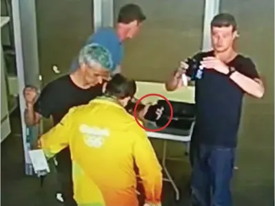  ??  ?? Footage: Lochte holds an item from his pocket, circled, for security following the alleged robbery