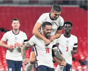  ??  ?? Danny Ings is mobbed after scoring England’s third goal