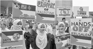  ??  ?? Muslims hold anti-Israel banners during the rally at the Putra Mosque. — Bernama photo