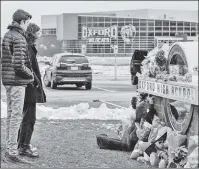  ?? ?? MOURNING: Students at Oxford HS in Michigan pay their respects at a school memorial after 15-year-old Ethan Crumbley (below) allegedly killed four classmates. Now his parents may face prosecutor­ial scrutiny.