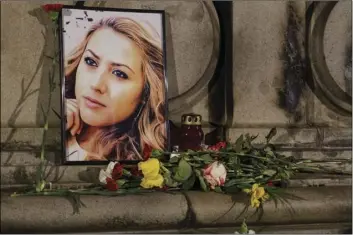  ?? PHOTO/FILIP DVORSKI ?? A portrait of slain television reporter Viktoria Marinova is placed on the Liberty Monument next to flowers and candles during a vigil in Ruse, Bulgariaon Tuesday. Bulgarian police are investigat­ing the rape, beating and slaying of Marinova, whose body was dumped near the Danube River after she reported on the possible misuse of European Union funds in Bulgaria. Authoritie­s discovered the body of 30-year-old Viktoria Marinova on Saturday in the northern town of Ruse near the Romanian border. One Bulgarian media site demanded an EU investigat­ion, fearing that Bulgarian o cials were complicit in the corruption. AP