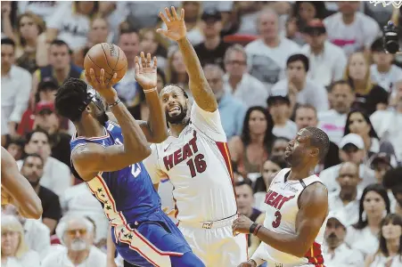  ?? AP PHOTO ?? LET FLY: Philadelph­ia’s Joel Embiid shoots under pressure from Miami’s James Johnson and Dwyane Wade in the fourth quarter of yesterday’s Game 4 in Miami. The Sixers surged in the second half to take a 3-1 series lead.