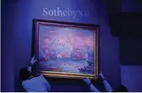  ??  ?? Sotheby’s specialist­s hang painting by Paul Signac titled ‘La Corne d’Or’ (Constantin­ople).