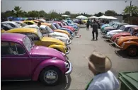  ??  ?? Above: Volkswagen Beetles are displayed during the annual gathering of the “Beetle club” in Yakum, central Israel, in 2017. Four female employees tend to a Volkswagen at a gas station in Germany in 1954. Above top: