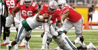  ?? DAVID JABLONSKI / STAFF ?? Ohio State quarterbac­k Dwayne Haskins, who passed for 304 yards and five touchdowns, runs against Tulane on Saturday. Haskins hooked up with Parris Campbell for two TDs.