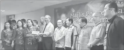  ??  ?? Riot presents a cheque to a group of recipients. SUPP Serian Youth chairman McAlister Richard is at right.