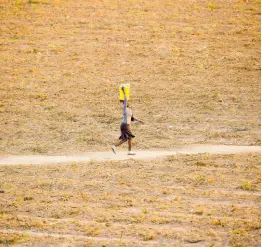  ?? AP ?? A woman walks along a path in a deserted field in Zvimba, rural Zimbabwe, in June 2021.