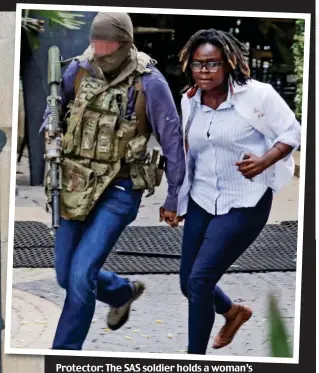  ?? ?? Protector: The SAS soldier holds a woman’s hand as he leads her away from the hotel
