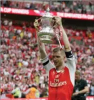  ?? MATT DUNHAM — THE ASSOCIATED PRESS ?? Arsenal’s Per Mertesacke­r celebrates with the trophy after winning the English FA Cup final over Chelsea on Saturday.