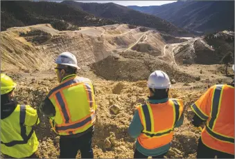  ?? NATHAN BURTON/Taos News ?? Chevron Mining, Inc. officials look out over the open pit at the closed Questa molybdenum mine, where remediatio­n activities have ramped up in recent months. Reclaiming the mine and tailings sites will likely take several more decades, and ‘Chevron will own the mine forever,’ a company official said.