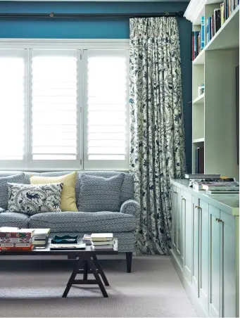  ??  ?? THIS PAGE (from left) A custom-built cabinet houses books, photos, ornaments and a TV in the media room which has white wooden shutters for privacy and curtains in a fabric from China Seas. The guest powder room, wallpapere­d in Seaweed Lace by Soane Britain, features a dark green pediment mirror by Bridie Hall At Home above a basin by Perrin & Rowe from In Residence. OPPOSITE A custom-made headboard upholstere­d in a green Schumacher velvet adds lushness to the guest bedroom; the cushions are from Jean Monro, made to match the curtains.