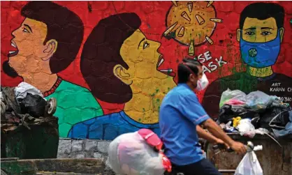  ?? ?? A cyclist passes a Covid awareness mural in New Delhi in July 2020. Photograph: Sajjad Hussain/AFP/Getty Images