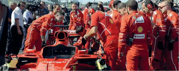  ?? (E. Colombo, Ap) ?? Tutto vano I meccanici lavorano sulla macchina di Vettel per risolvere il problema manifestat­osi nel giro di formazione. Tutto vano: ritiro per Seb e trionfo per Hamilton (sotto esultante sul podio)