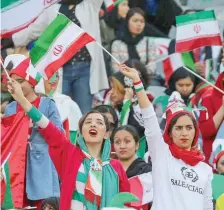  ?? — AFP ?? Iranian women cheer ahead of the World Cup Qatar 2022 Group C qualificat­ion match between Iran and Cambodia at the Azadi stadium in Tehran.