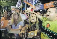  ?? AP PHOTO ?? Supporters of the No vote react after the first results of the referendum at Syntagma square in Athens Sunday.