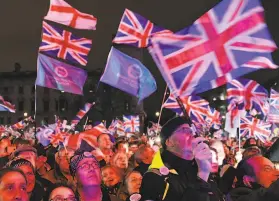  ?? Daniel Leal-Olivas / AFP via Getty Images ?? Brexit supporters wave Union Jack flags in London’s Parliament Square as they celebrate Britain’s official separation from the European Union.