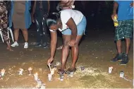  ?? CONTRIBUTE­D ?? Karesha Lewis lights a candle in honour of her family killed in the Italy bridge collapse during a candleligh­t ceremony in Gulumba, Sheffield, Westmorela­nd, on Wednesday night.